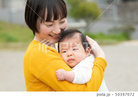 赤ちゃんを抱く若い母親 日本人親子の写真素材