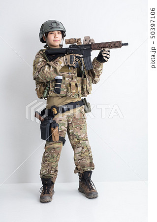 白背景に迷彩服を全身着たかっこいい女の子が銃を持っているサバイバルゲームサバゲー体験  50397106