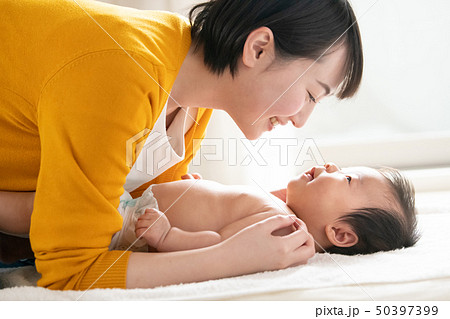 赤ちゃんをあやす若い母親 日本人親子の写真素材
