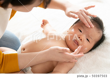 赤ちゃんにクリームを塗る若い母親 育児 子育て 50397503