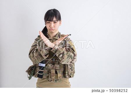 白背景に迷彩服の女の子が笑顔で手で不正解バツと表示しているサバイバルゲーム 白背景に迷彩服の女の子が笑顔で手で不正解バツと表示しているサバイバルゲーム 50398252