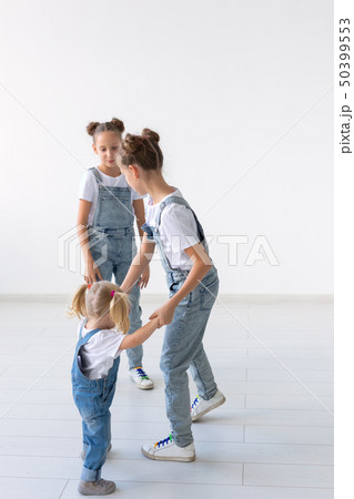 Family and love concept - Three sisters hugging over white background Family and love concept - Three sisters hugging over white background 50399553