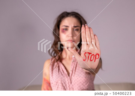Domestic violence, protesting and people concept - brunette woman expressing denial with STOP on her Domestic violence, protesting and people concept - brunette woman expressing denial with STOP on her 50400223