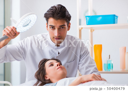 Young woman visiting male doctor cosmetologist 50400479