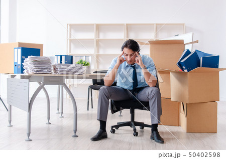 Young man employee with boxes in the office  50402598