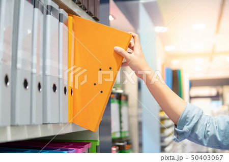 Male hand choosing file folder in stationery shop Male hand choosing file folder in stationery shop 50403067