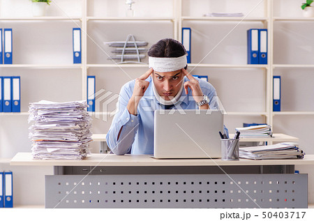 Young injured male employee working in the office Young injured male employee working in the office 50403717