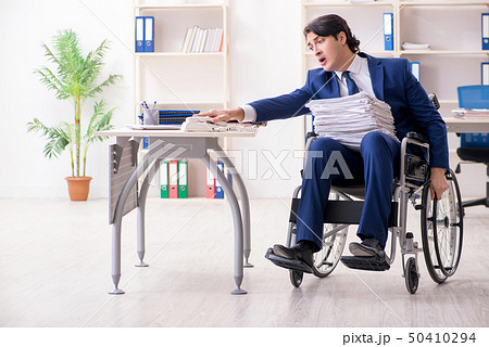 Young male employee in wheelchair working in the office Young male employee in wheelchair working in the office 50410294