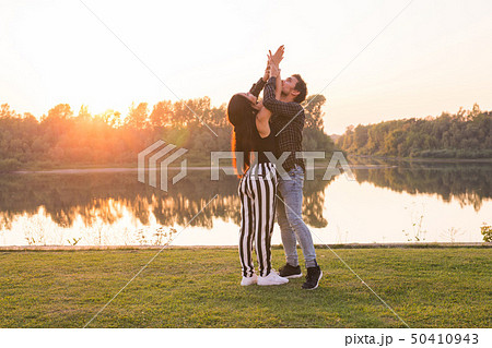 Romantic, social dance and people concept - young couple dancing a tango or bachata near the lake Romantic, social dance and people concept - young couple dancing a tango or bachata near the lake 50410943