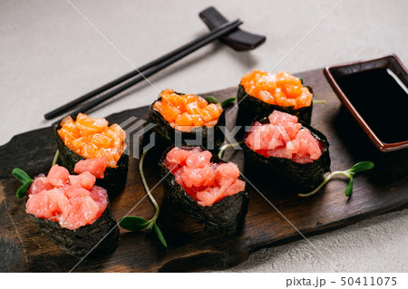 Seafood gunkan maki sushi rolls on wooden plate Seafood gunkan maki sushi rolls on wooden plate 50411075