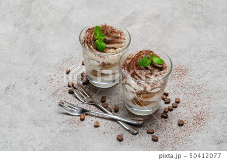 two portions Classic tiramisu dessert in a glass on concrete background 50412077