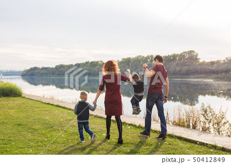 Parent, childhood and nature concept - Family playing with two sons by the water 50412849