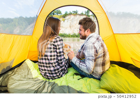 people, summer tourism and nature concept - young couple resting in camping tent, view from inside people, summer tourism and nature concept - young couple resting in camping tent, view from inside 50412952