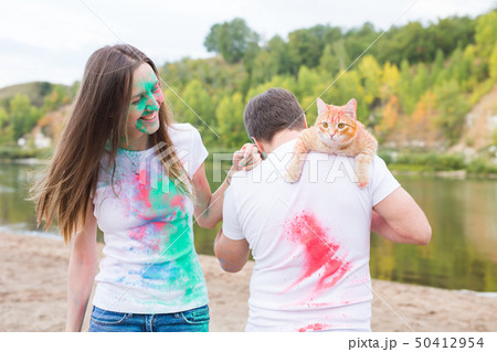 Festival holi, tourism and nature concept - Portrait of woman and man with cat covered multi-colored 50412954