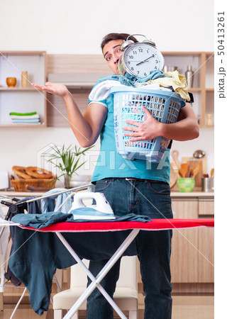 Young man husband doing clothing ironing at home  50413261