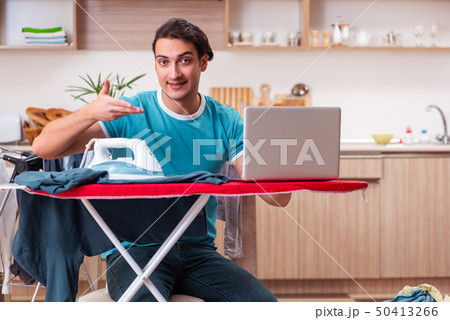 Young man husband doing clothing ironing at home Young man husband doing clothing ironing at home 50413266
