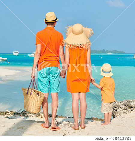 Family of three on beach under palm tree Family of three on beach under palm tree 50413735
