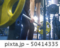 woman with a barbell doing exercises in the gym 50414335