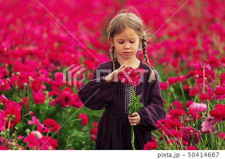 Sweet little girl in a meadow with wild spring flowers, Art retouching photo 50414667