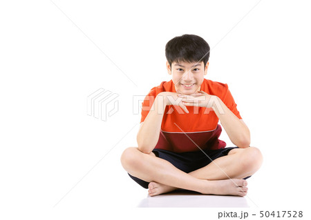 Young Asian boy sitting over white background Young Asian boy sitting over white background 50417528