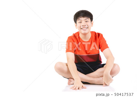 Young Asian boy sitting over white background Young Asian boy sitting over white background 50417537