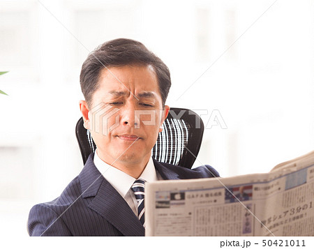 オフィスで新聞を読むビジネスマン オフィスで新聞を読むビジネスマン 50421011