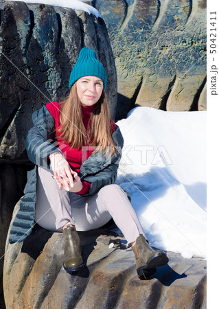 girl in emerald knitted hat in the sun on large tires girl in emerald knitted hat in the sun on large tires 50421411