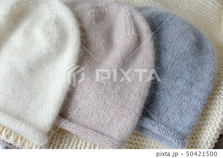 Three hats of the same style in blue, beige and white made of wool on the spokes Three hats of the same style in blue, beige and white made of wool on the spokes 50421500