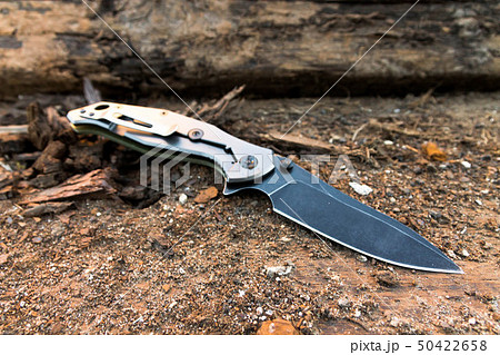Tactical knife with a black blade on a background Tactical knife with a black blade on a background 50422658