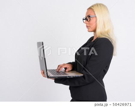 Profile view of young beautiful blonde businesswoman using laptop 50426971
