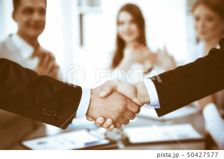 Business people shaking hands at meeting while theirs colleagues clapping and applauding. Group of Business people shaking hands at meeting while theirs colleagues clapping and applauding. Group of 50427577