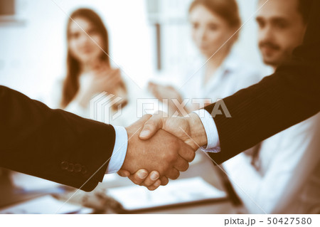 Business people shaking hands at meeting while theirs colleagues clapping and applauding. Group of Business people shaking hands at meeting while theirs colleagues clapping and applauding. Group of 50427580