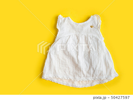 Beautiful cotton muslin vintage baby girl white dress on yellow background - summer Beautiful cotton muslin vintage baby girl white dress on yellow background - summer 50427597