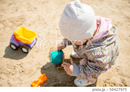 Family day in the park. Happy young couple with newborn baby. Mother carry baby in ergonomic baby Family day in the park. Happy young couple with newborn baby. Mother carry baby in ergonomic baby 50427975