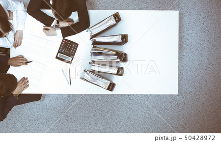 Business people at meeting, view from above. Bookkeeper or financial inspector making report Business people at meeting, view from above. Bookkeeper or financial inspector making report 50428972
