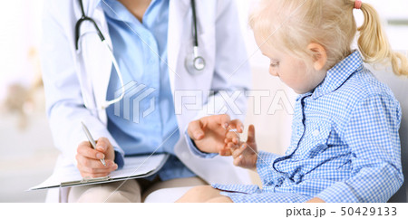 Doctor and a little blonde girl. Usual health exam. Medicine and healthcare concept Doctor and a little blonde girl. Usual health exam. Medicine and healthcare concept 50429133