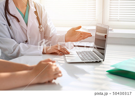 Doctor and patient are discussing something in clinic, just hands at the desk. Medicine and best Doctor and patient are discussing something in clinic, just hands at the desk. Medicine and best 50430317
