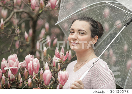 Spring Beautiful romantic red haired girl in white lace dress and jeans standing near blooming tree Spring Beautiful romantic red haired girl in white lace dress and jeans standing near blooming tree 50430578