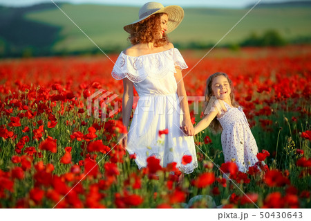 Beauty mother with teen enjoy summer days .Cute fancy dressed girl in poppy field. Field of blooming Beauty mother with teen enjoy summer days .Cute fancy dressed girl in poppy field. Field of blooming 50430643