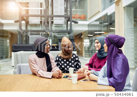 Muslim young women of diverse ethnicity talking about new book of famous author 50434061