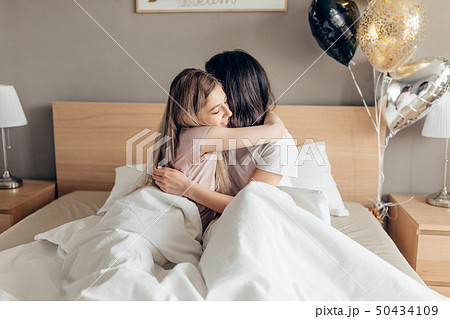 kind sister kissing her elder sister good night. 50434109