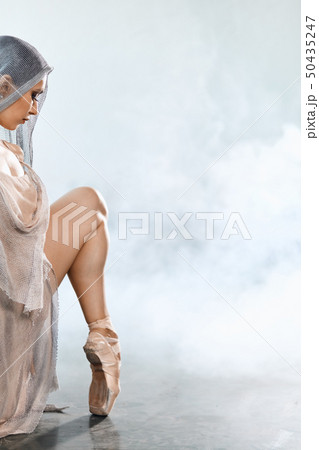 Flexible ballet dancer stretching in the dark lighted studio Flexible ballet dancer stretching in the dark lighted studio 50435247