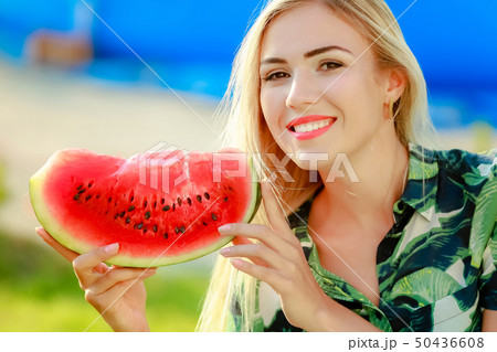 Portrait of cute girl makes funny face and smile with watermelon slices. Beautiful woman eating ripe 50436608