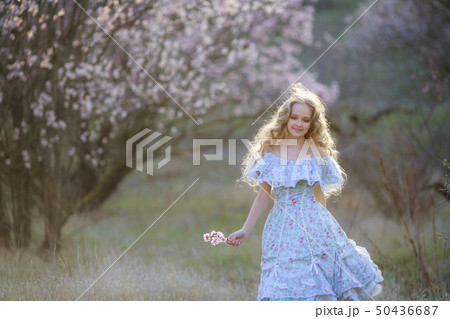 Sweet woman in a beautiful dress dancing in a park with long hair Sweet woman in a beautiful dress dancing in a park with long hair 50436687