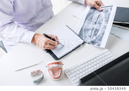 Male doctor or dentist writing report working with Male doctor or dentist writing report working with 50438349