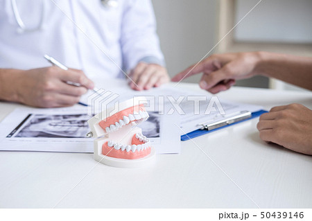 Male doctor or dentist writing report working with Male doctor or dentist writing report working with 50439146