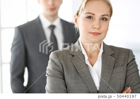 Business woman standing straight with colleague businessman in office, headshot. Success and Business woman standing straight with colleague businessman in office, headshot. Success and 50440197
