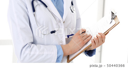 Female doctor using medical form on clipboard closeup. Physicianat work in hospital or clinic Female doctor using medical form on clipboard closeup. Physicianat work in hospital or clinic 50440366