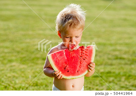 One year old baby boy eating watermelon in the 50441964