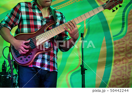 Bass guitar player on stage of ethnic open air concert Bass guitar player on stage of ethnic open air concert 50442244